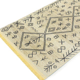 Esquina de la capa superior de la alfombra 'Melilla', enfocándose en los detalles vibrantes y los patrones geométricos. Esta pieza atemporal es lavable en lavadora, ofreciendo una combinación de estilo y funcionalidad.