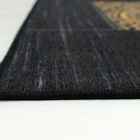 Esquina de la alfombra 'Mosaic', mostrando los detalles del diseño intrincado con patrones dorados. Esta elegante alfombra añade distinción a cualquier espacio y es lavable en lavadora para facilitar su cuidado.