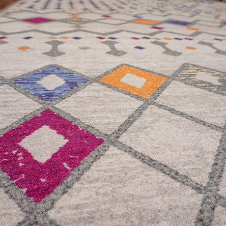Primer plano de la alfombra 'Nadia', mostrando el detallado patrón en tonos púrpura, naranja, gris y blanco. Esta pieza moderna y vibrante es también lavable en lavadora, combinando estilo con practicidad.